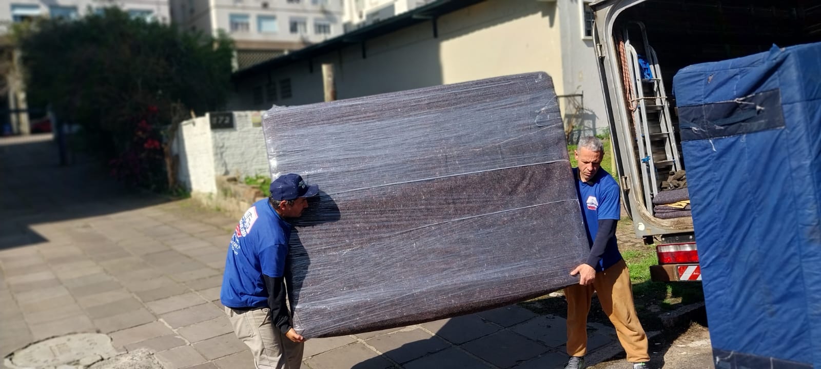 Equipe carregando móvel protegido